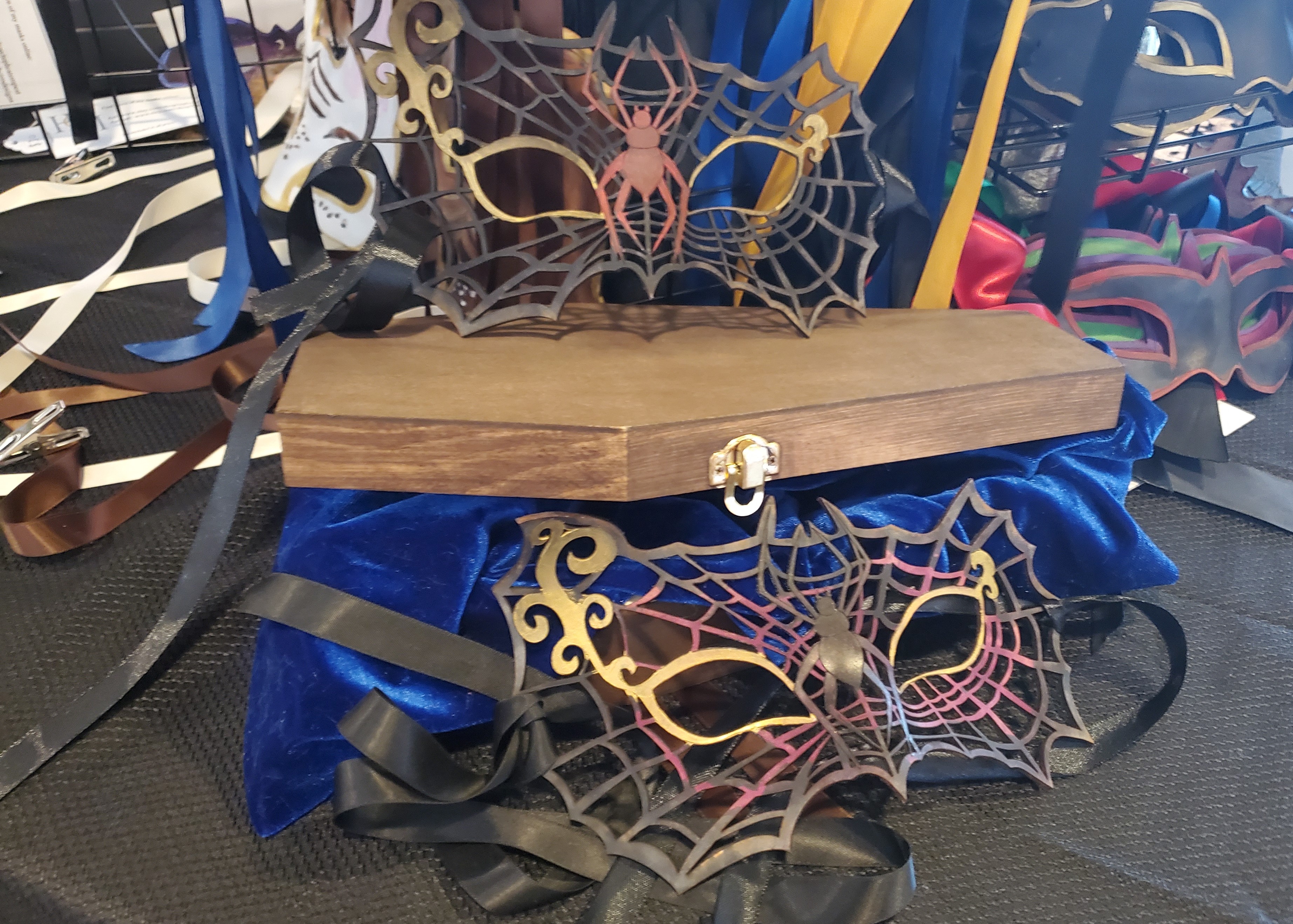 Photo of Spider Masquerade masks on top of a coffin.