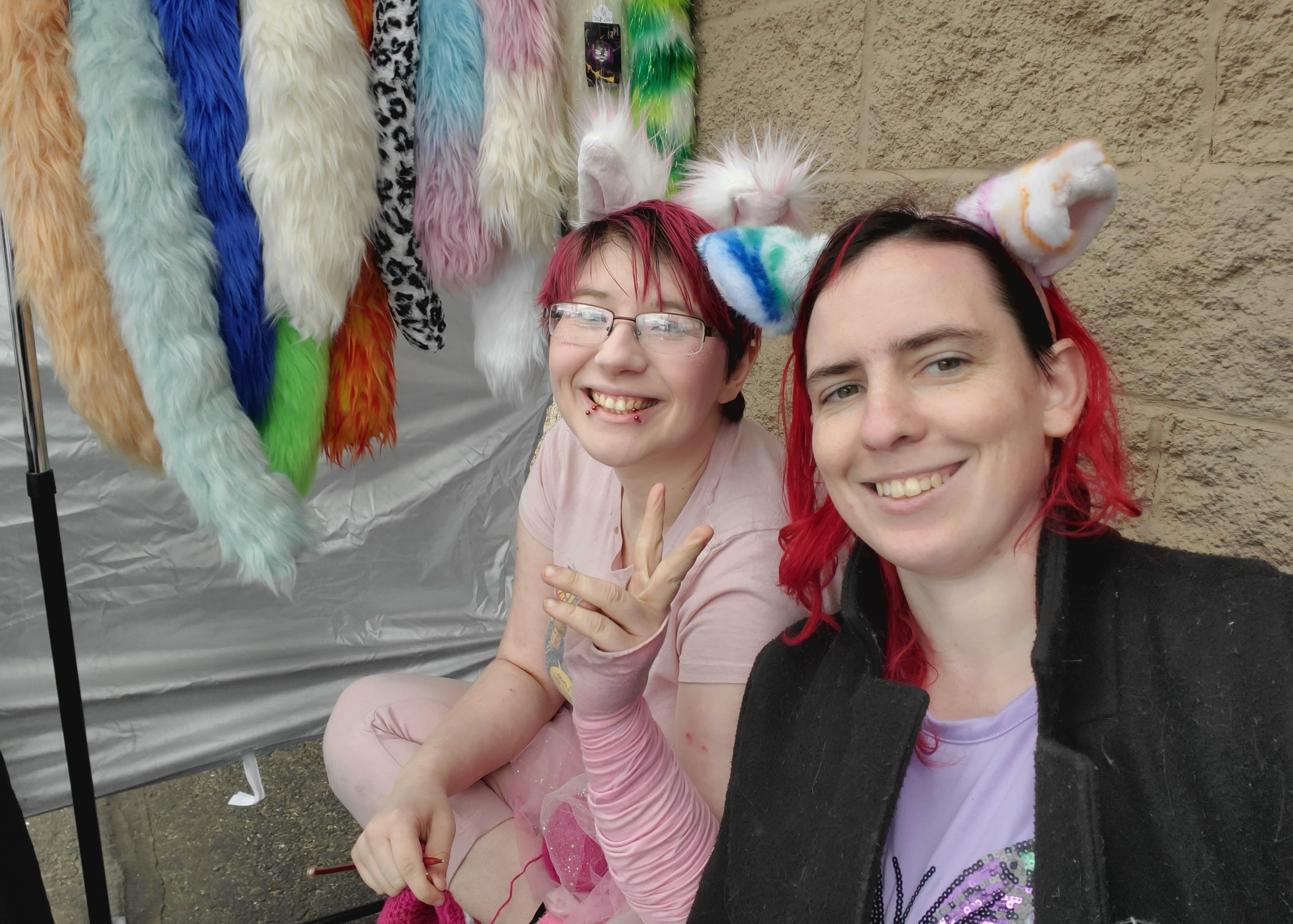 Photo of two vendors wearing cat ears and smiling.