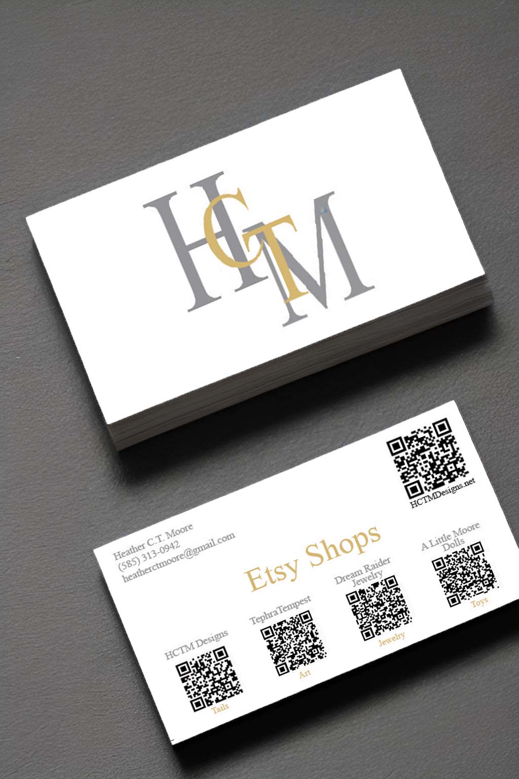 Image of a stack of business cards split. One side with the HCTMDesign Logo on them centered in white space, the other side with Business info and 5 QR codes on the back.