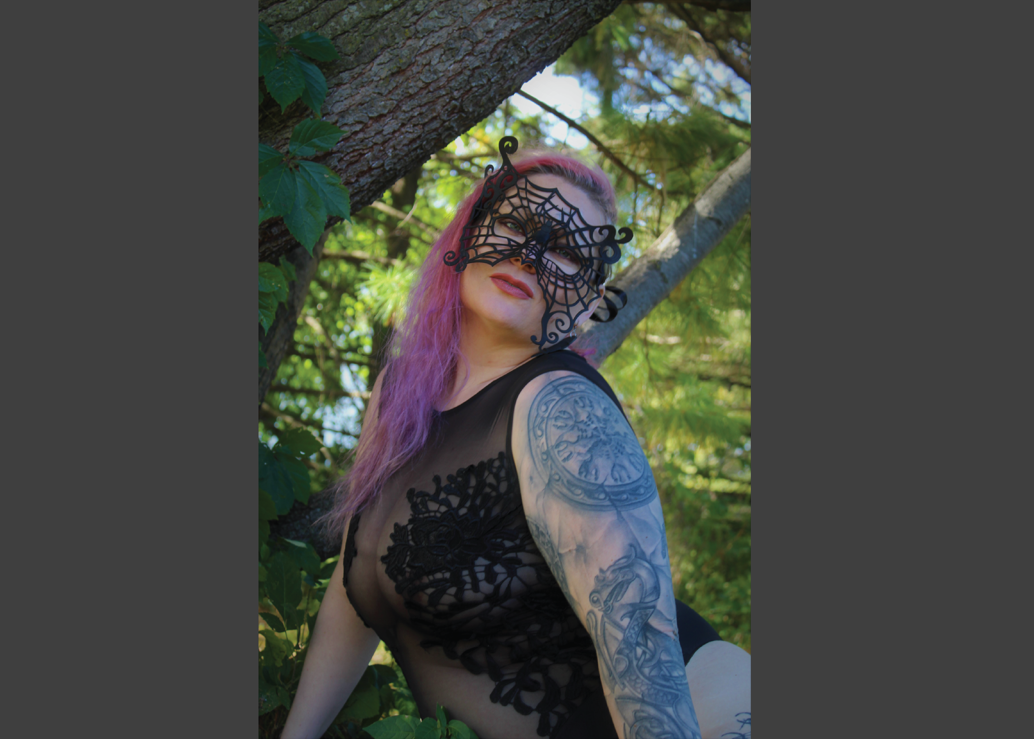 Photo of a Beautiful Woman with Pink Hair posing in black lingerie wearing a beautiful, spiderweb mask. Masquerade style mask made of leather, looks like iace.