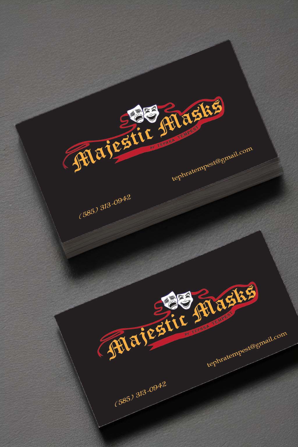 Image of a deck of black business cards with the logo for Majestic Masks, and business information on them.